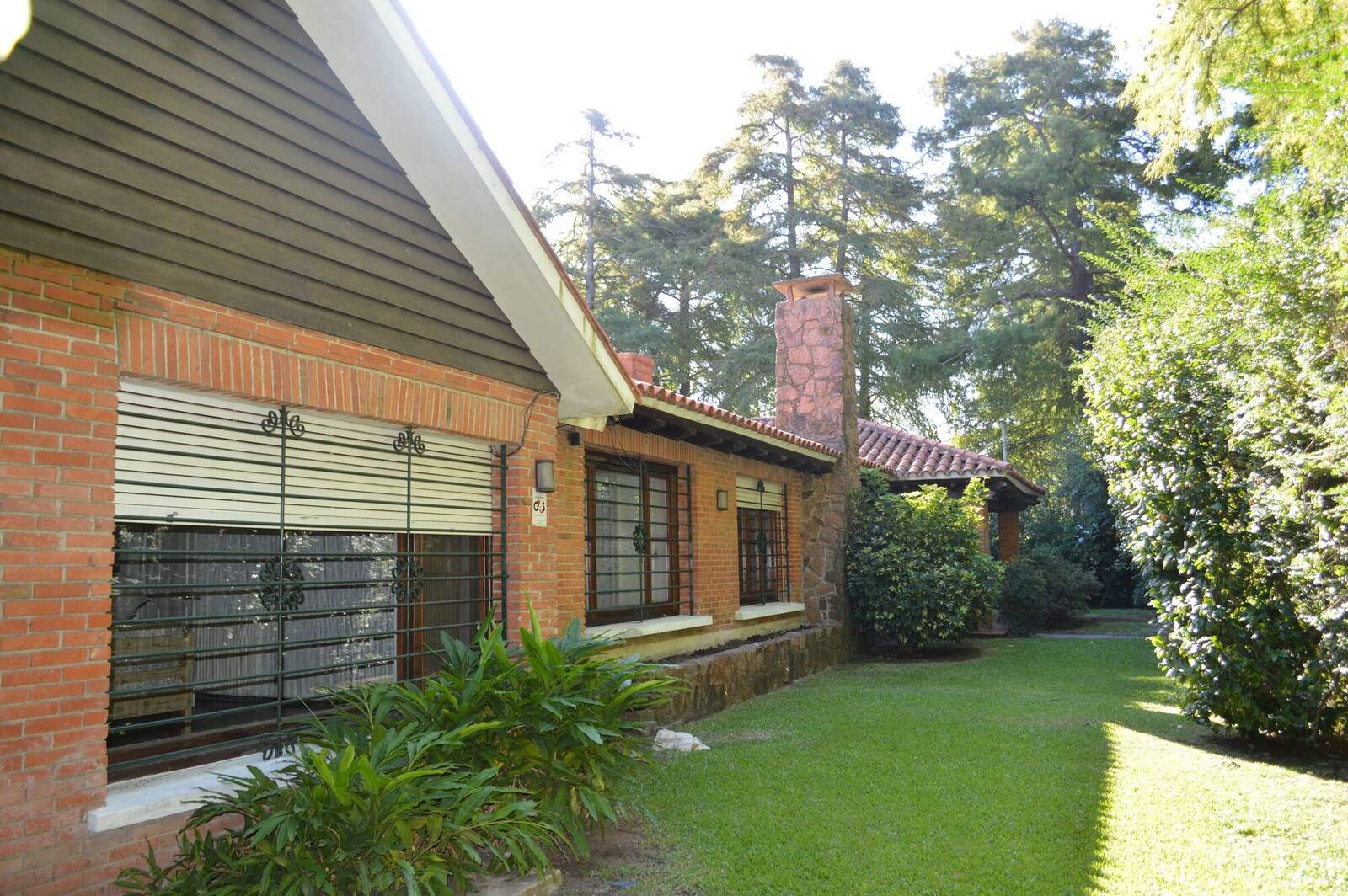 Frente de ladrillo de la casa de Manas con el jardín